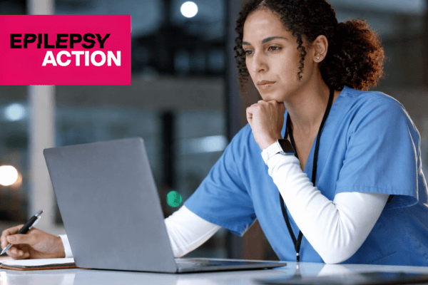 Focuses on a clinical pharmacist reviewing epilepsy medication on a laptop in a healthcare setting.