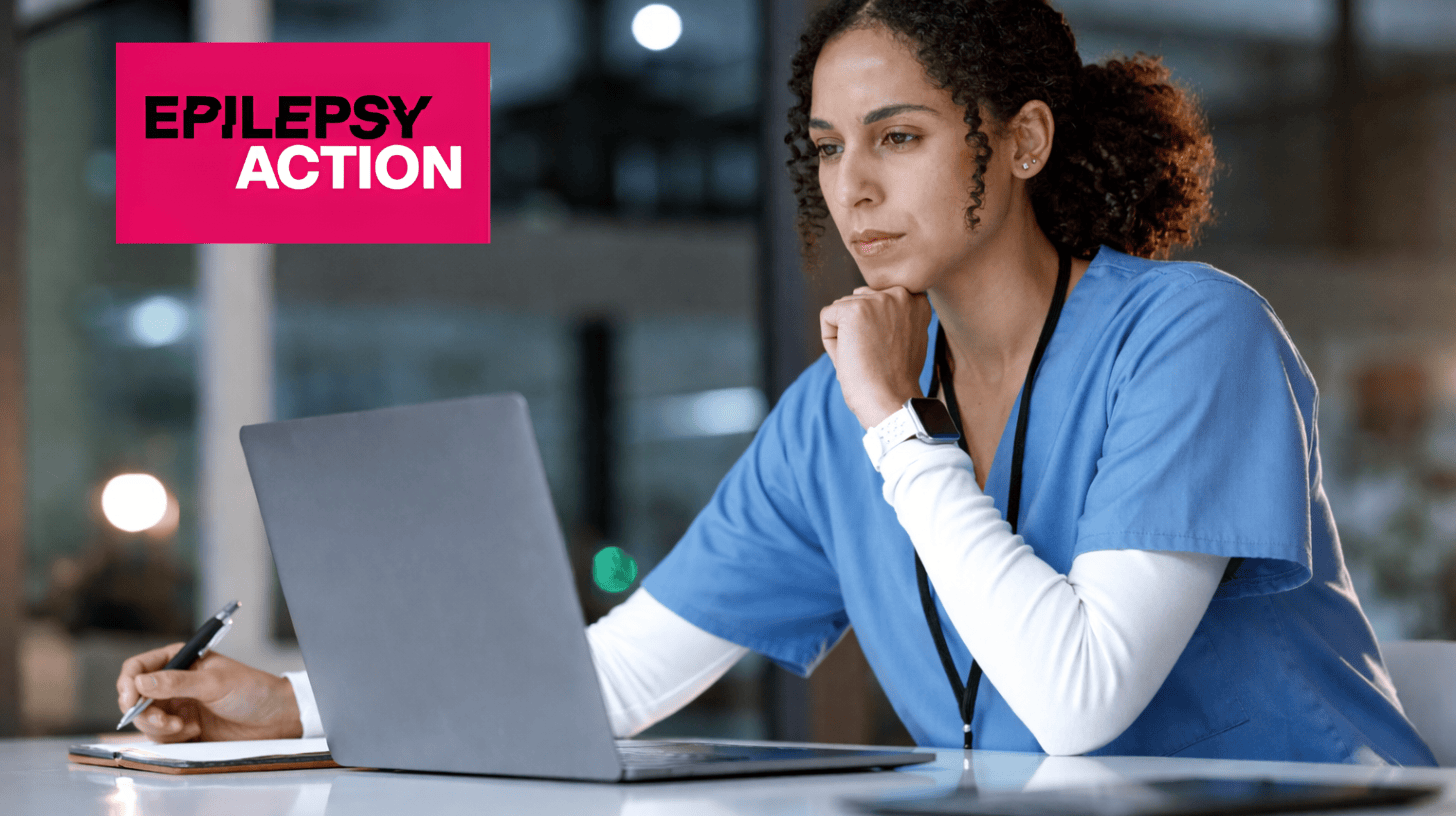 Focuses on a clinical pharmacist reviewing epilepsy medication on a laptop in a healthcare setting.