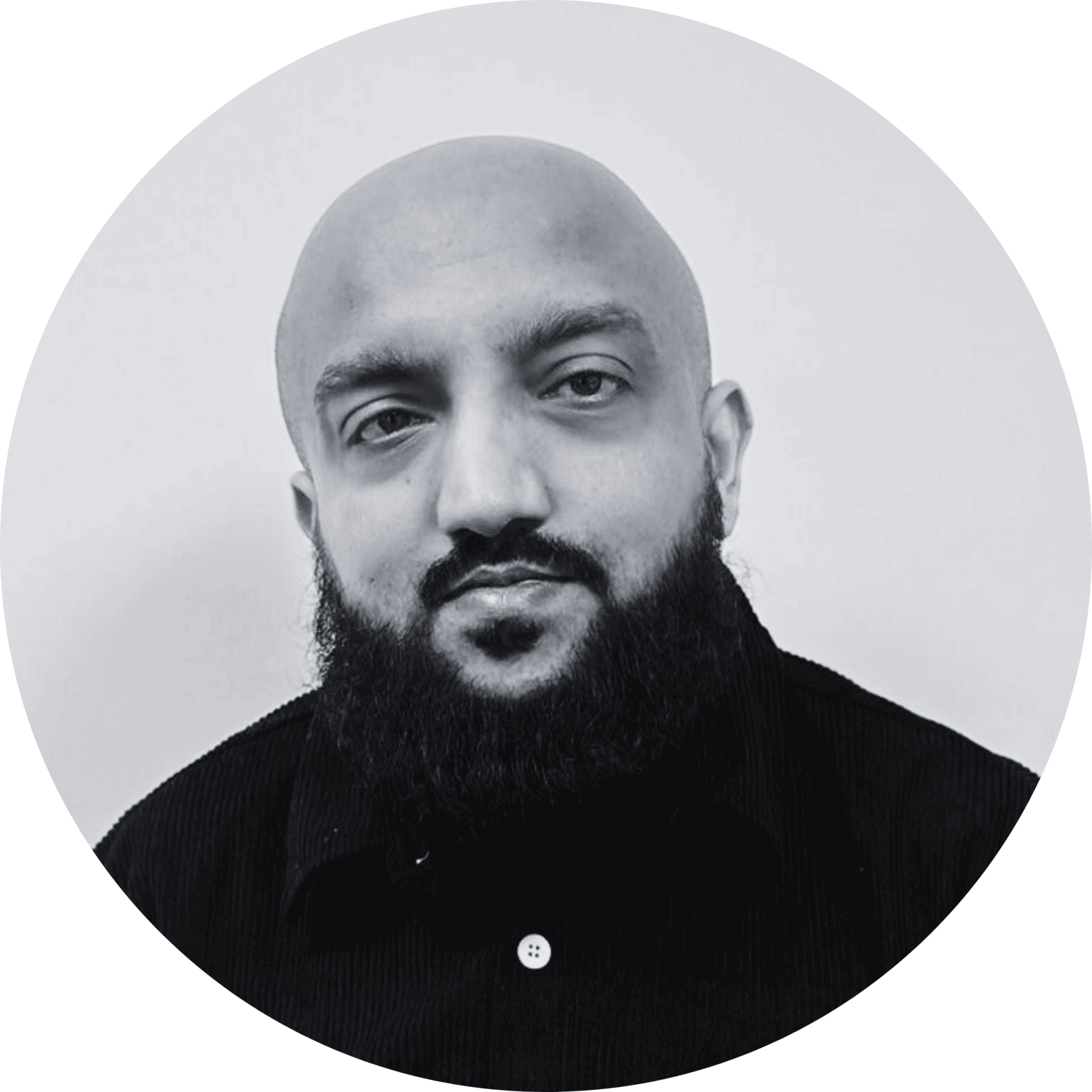 A clinical pharmacist with a beard and bald head, wearing a black shirt, in a professional portrait.